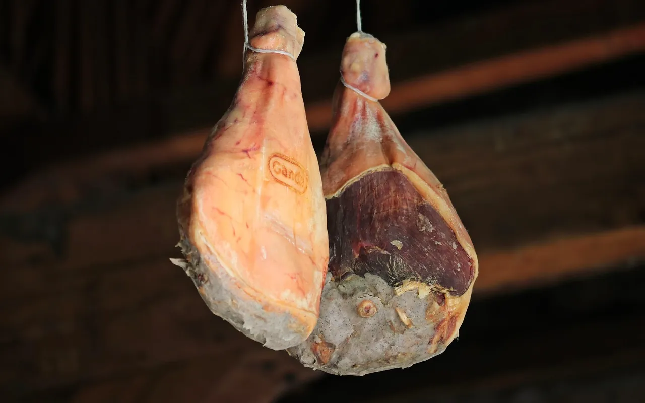 Des jambons qui sèchent, pendus aux poutres du séchoir