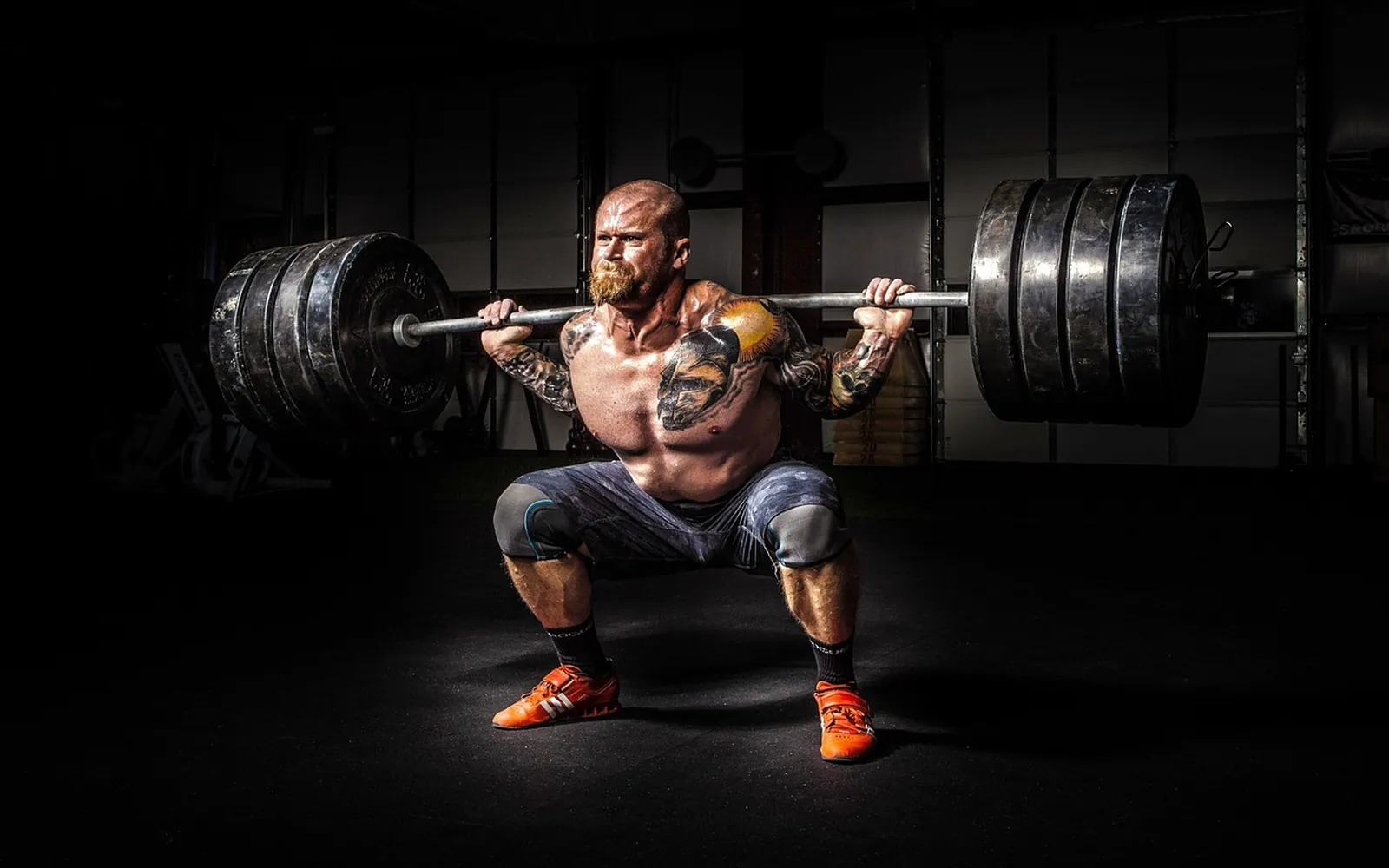Un athlète en squat avec une barre chargée